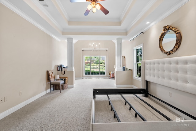 interior space with decorative columns, a raised ceiling, and ornamental molding