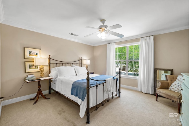 bedroom with light colored carpet, visible vents, ceiling fan, baseboards, and ornamental molding