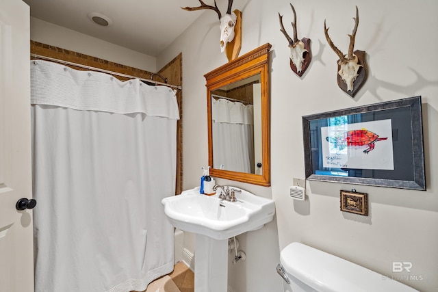 full bath with toilet and a shower with shower curtain