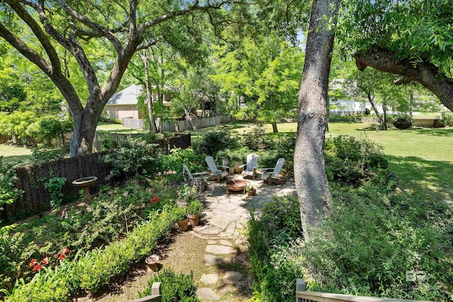 view of yard featuring a patio, a fire pit, and fence