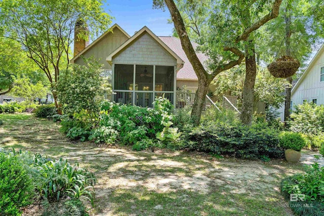back of property featuring a chimney and a sunroom