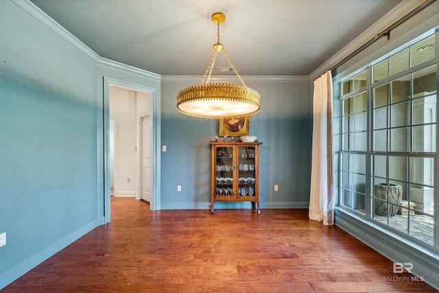 dining room featuring wood finished floors, ornamental molding, and baseboards