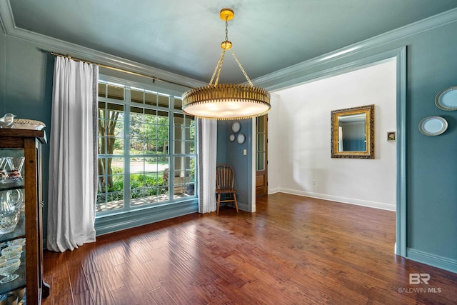 unfurnished dining area with wood finished floors, ornamental molding, and baseboards