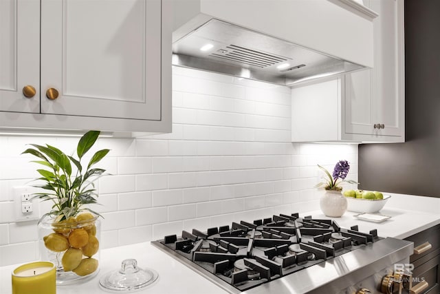 kitchen featuring decorative backsplash, stainless steel range, and wall chimney exhaust hood