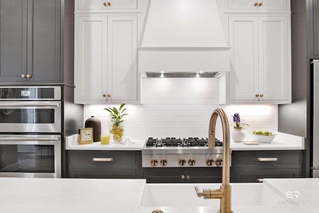 kitchen featuring white cabinets, backsplash, and stainless steel appliances