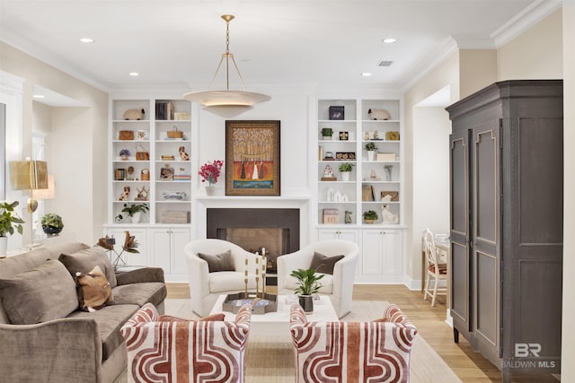 living area with built in features, light hardwood / wood-style flooring, and crown molding