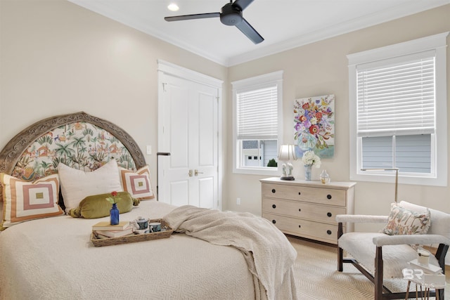 carpeted bedroom with a closet, ceiling fan, and crown molding