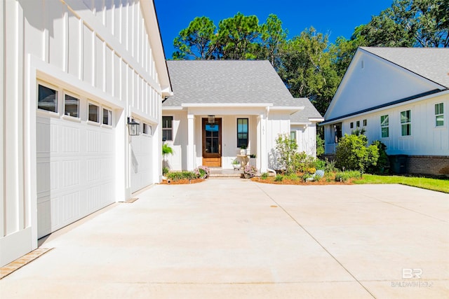 modern inspired farmhouse with a garage and covered porch