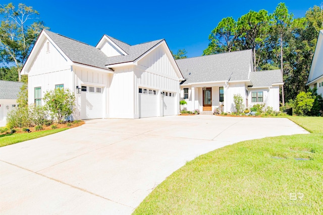 modern farmhouse style home featuring a front lawn and a garage