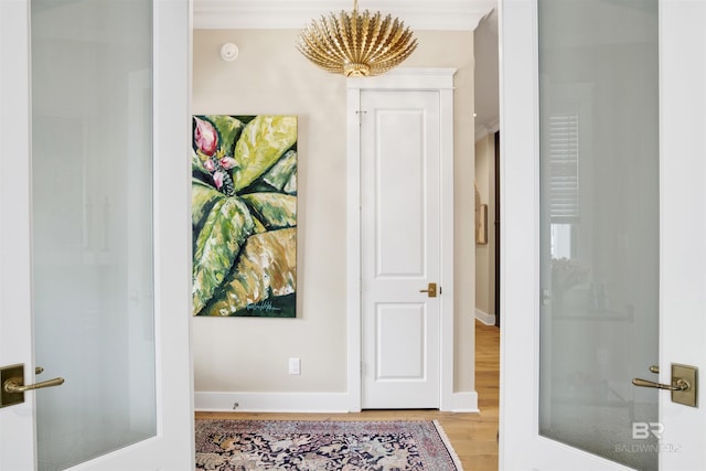 hall featuring light hardwood / wood-style floors and crown molding