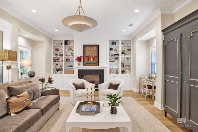 living room featuring a healthy amount of sunlight, ornamental molding, built in features, and light hardwood / wood-style flooring