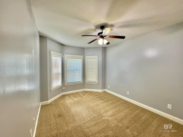 carpeted empty room with ceiling fan and a textured ceiling