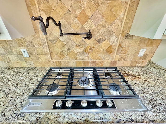 details with stone counters, stainless steel gas cooktop, and tasteful backsplash