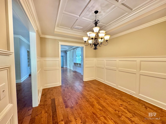 unfurnished dining area with ornamental molding, a chandelier, wood-type flooring, and coffered ceiling