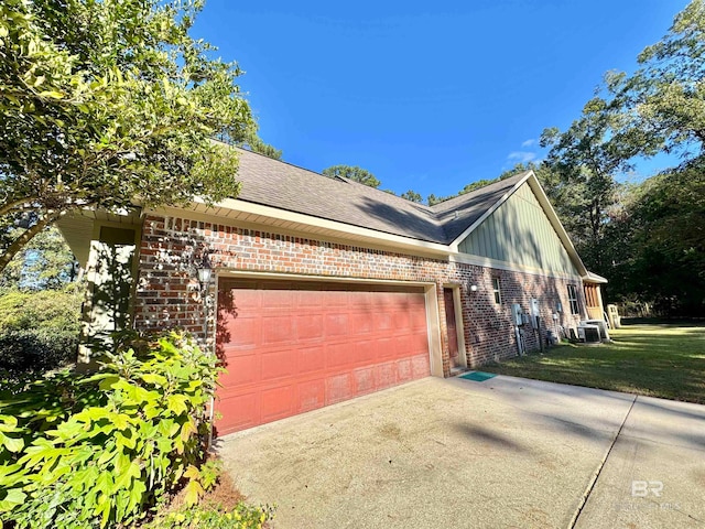 view of property exterior with central air condition unit, a yard, and a garage