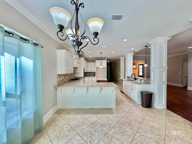 kitchen with decorative columns, white cabinetry, kitchen peninsula, and pendant lighting