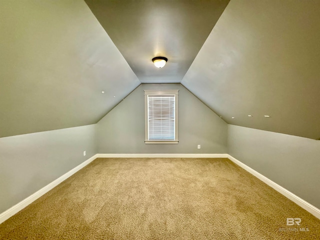 additional living space with lofted ceiling and carpet flooring