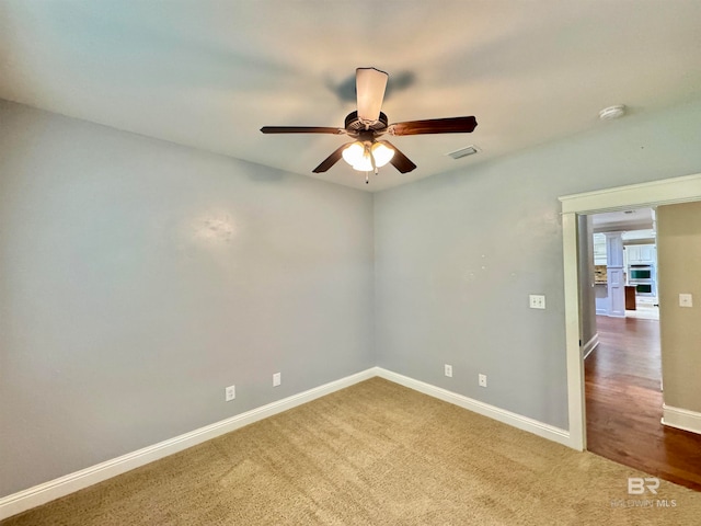 carpeted spare room with ceiling fan