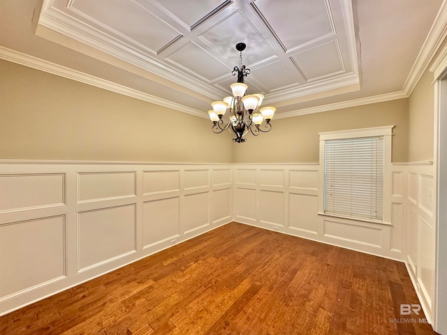 empty room featuring wood-type flooring, an inviting chandelier, and ornamental molding