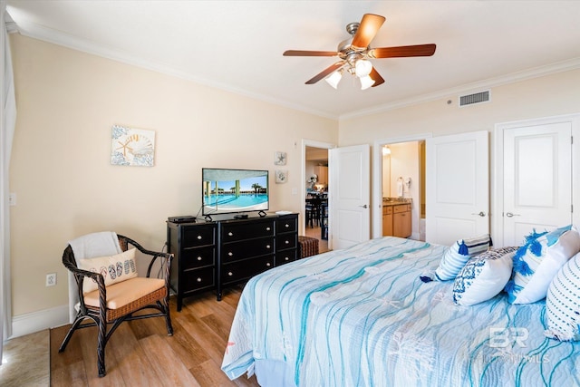 bedroom with visible vents, light wood-style flooring, ornamental molding, ceiling fan, and baseboards