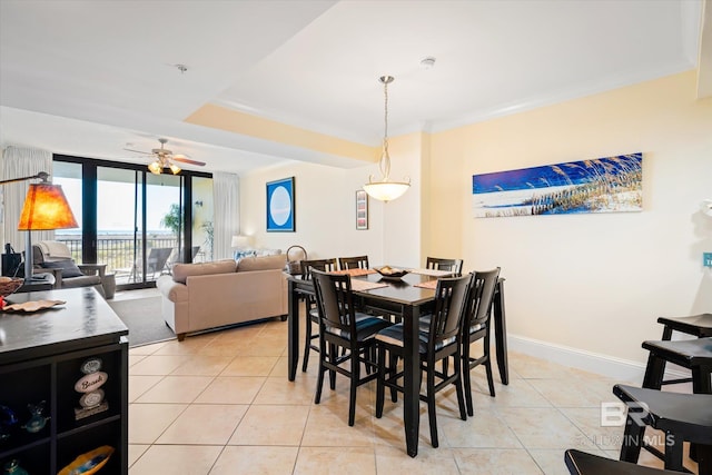 dining space with baseboards, a ceiling fan, crown molding, floor to ceiling windows, and light tile patterned flooring