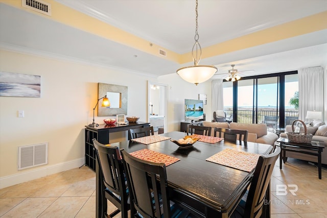 dining room with light tile patterned floors, visible vents, and crown molding