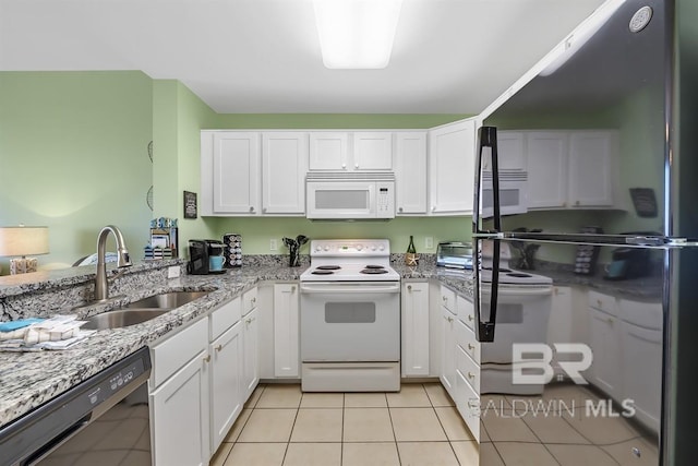 kitchen with light tile patterned floors, white cabinets, white appliances, and a sink