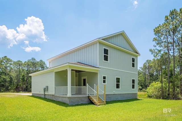 657 Island Way, Gulf Shores, AL 36542 - view of front facade with board and batten siding, a front yard, and a porch