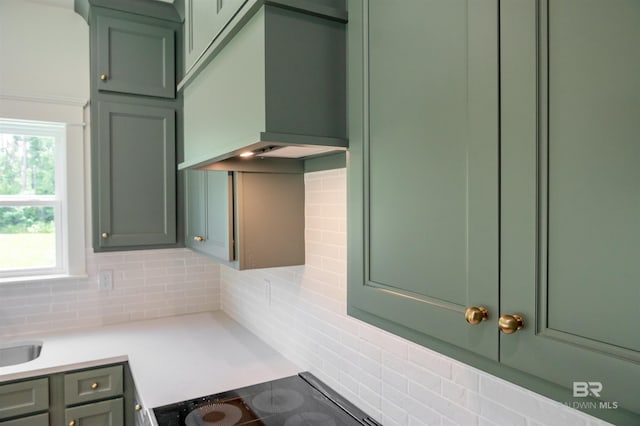 657 Island Way, Gulf Shores, AL 36542 - kitchen with green cabinets, tasteful backsplash, and black electric stovetop