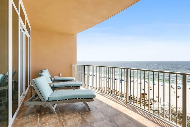 balcony featuring a water view and a beach view