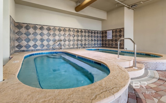 view of swimming pool with an indoor hot tub