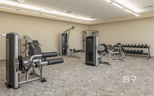 workout area featuring baseboards, visible vents, and light colored carpet