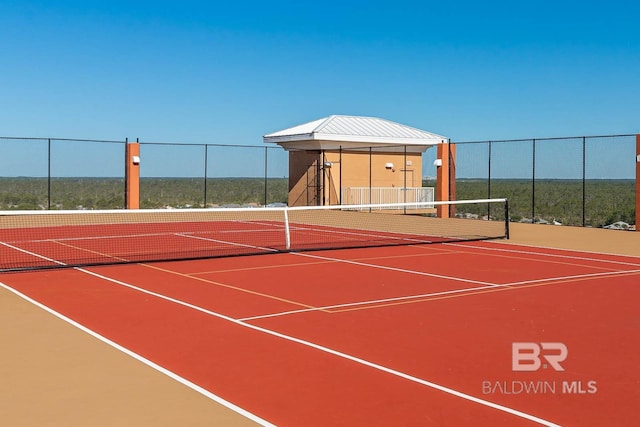 view of tennis court featuring community basketball court and fence