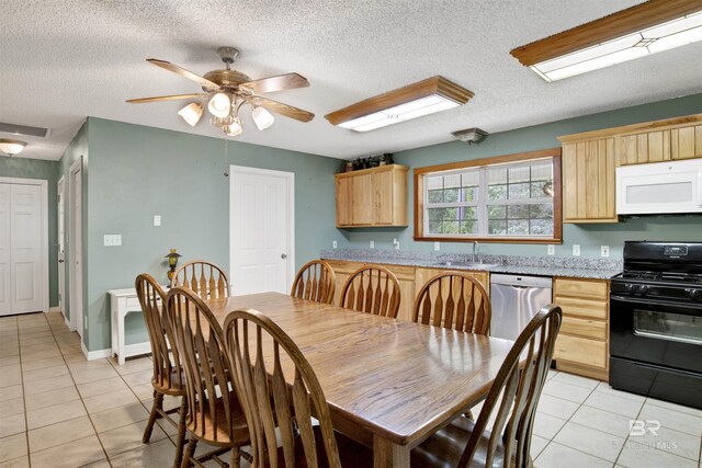 tiled dining area with a textured ceiling, sink, and ceiling fan