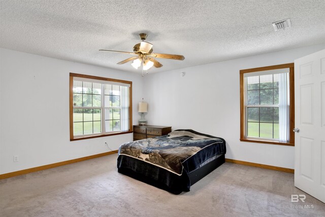 carpeted bedroom featuring a textured ceiling and ceiling fan