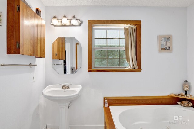 bathroom with a textured ceiling and a tub