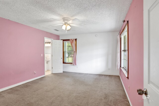 spare room with a textured ceiling, carpet, and ceiling fan