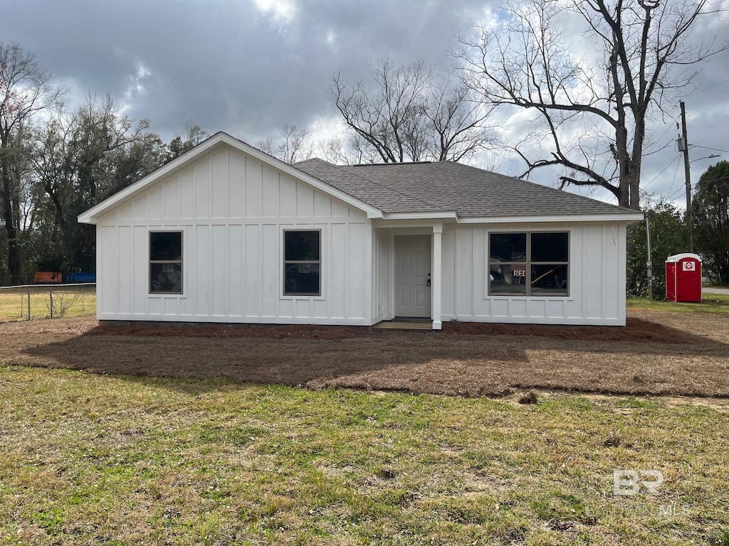 view of front of house with a front lawn and a shed