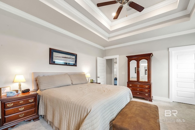 bedroom with crown molding, baseboards, a tray ceiling, and light carpet