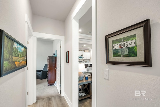 corridor featuring baseboards and wood finished floors