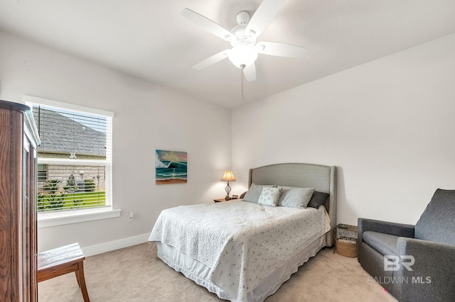 bedroom featuring baseboards, light carpet, and a ceiling fan