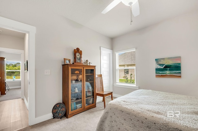 bedroom with baseboards, ceiling fan, and light colored carpet