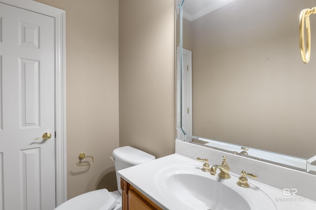 bathroom featuring crown molding, vanity, and toilet