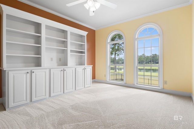 carpeted empty room featuring ceiling fan and ornamental molding