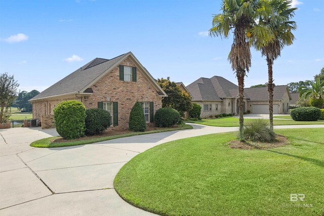 view of front facade featuring central AC unit, a front yard, and a garage