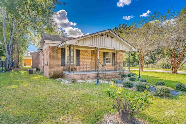 bungalow-style home featuring a front lawn, a porch, and cooling unit