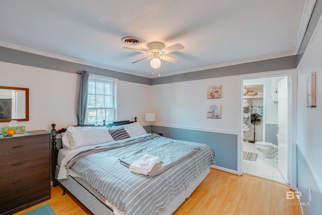 bedroom featuring ensuite bath, light hardwood / wood-style flooring, ceiling fan, and crown molding