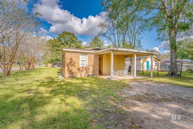 rear view of house featuring a lawn and a patio area