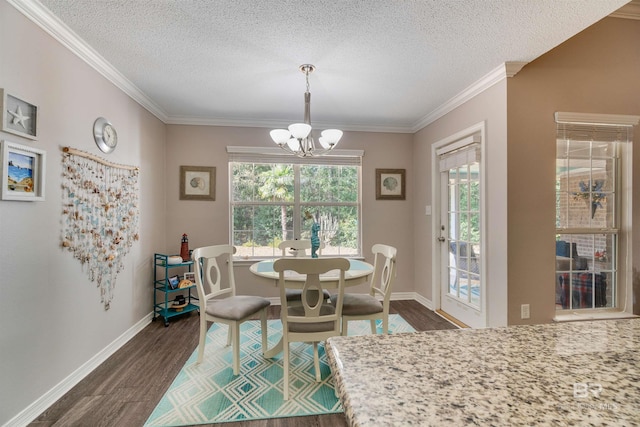 dining space with dark wood-type flooring, ornamental molding, an inviting chandelier, and a textured ceiling