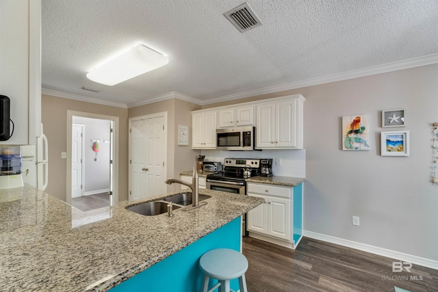 kitchen featuring appliances with stainless steel finishes, sink, white cabinets, and light stone counters